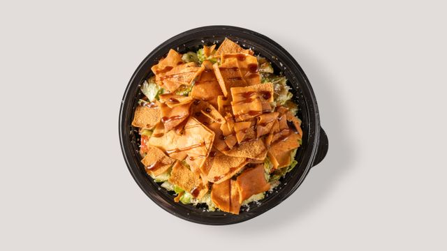 Top view of a colorful fattoush salad with crispy pita and rich dressing.