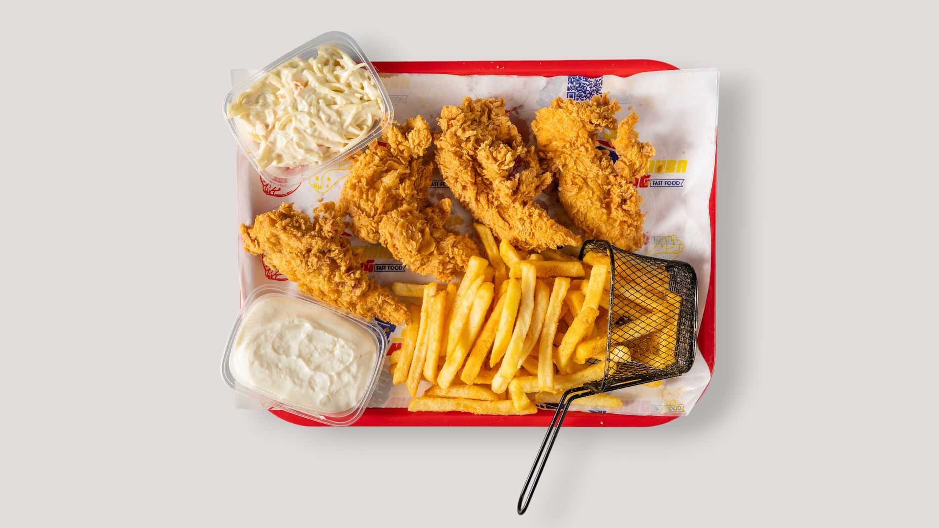 Crispy fried chicken, golden fries, coleslaw, and sauce served on a tray