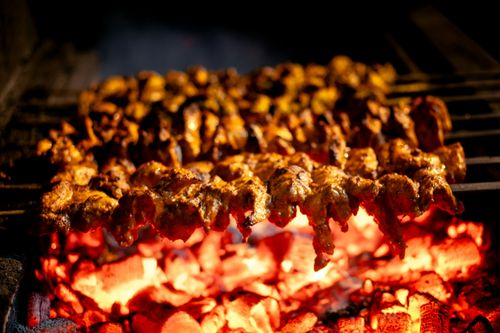 Free Close-up of marinated chicken skewers grilling on open flame, capturing the essence of a BBQ feast. Stock Photo