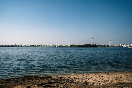 Free A panoramic view of Al Mamzar Beach, Sharjah with clear skies and UAE flag visible. Stock Photo
