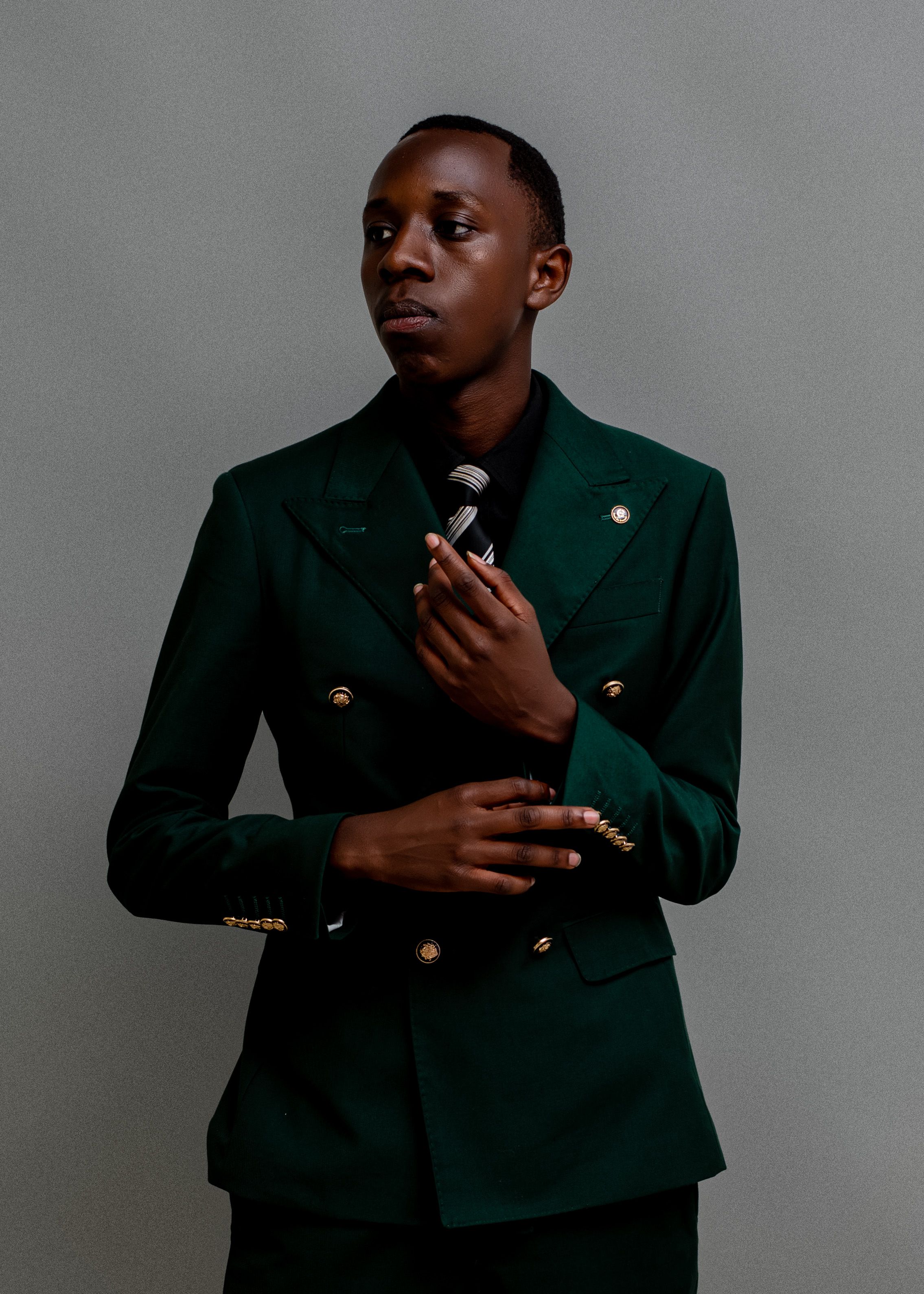 Portrait of a man in a green suit holding a microphone, exuding elegance.