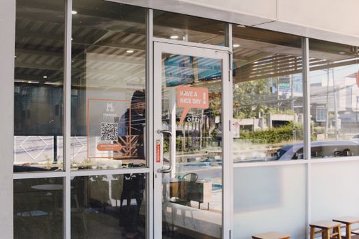 Glass door entrance to a cafe with signage reading 'Have a Nice Day'.