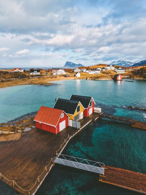 Free A stunning aerial shot of colorful coastal houses surrounded by clear waters in Sommarøy, Norway. Stock Photo