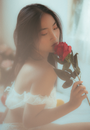 一位优雅的女人手持红玫瑰的肖像，散发着迷人的美丽