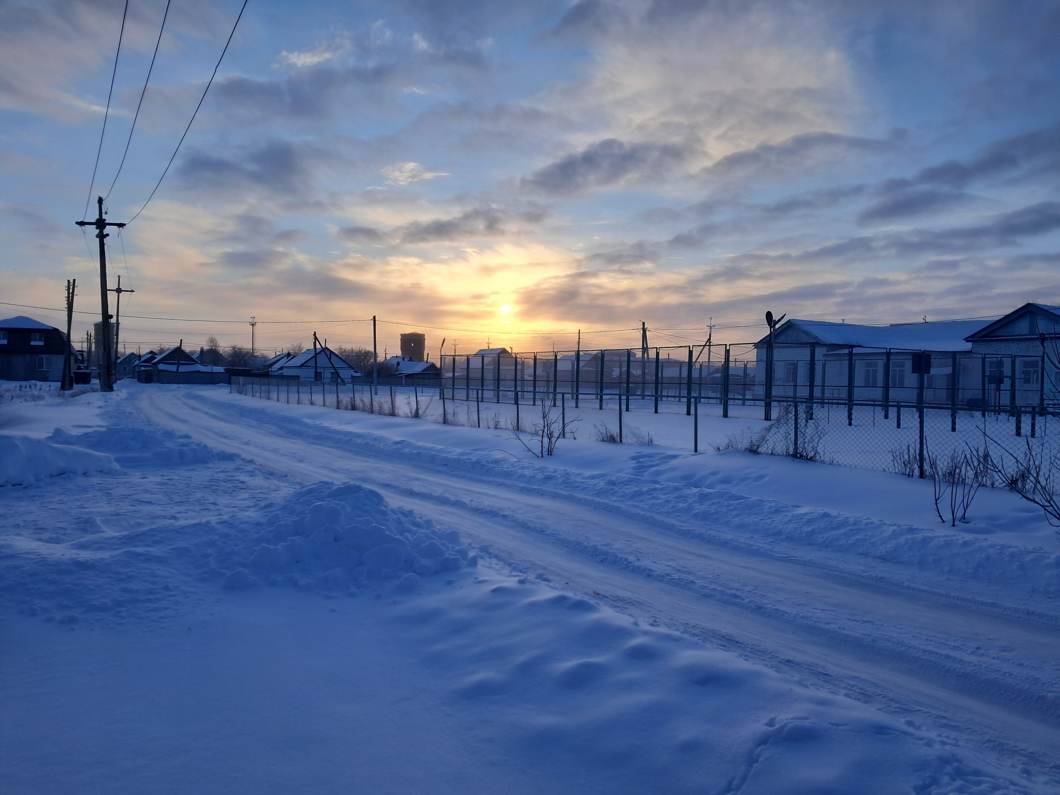 Amanecer de invierno sobre un pueblo nevado en Rusia