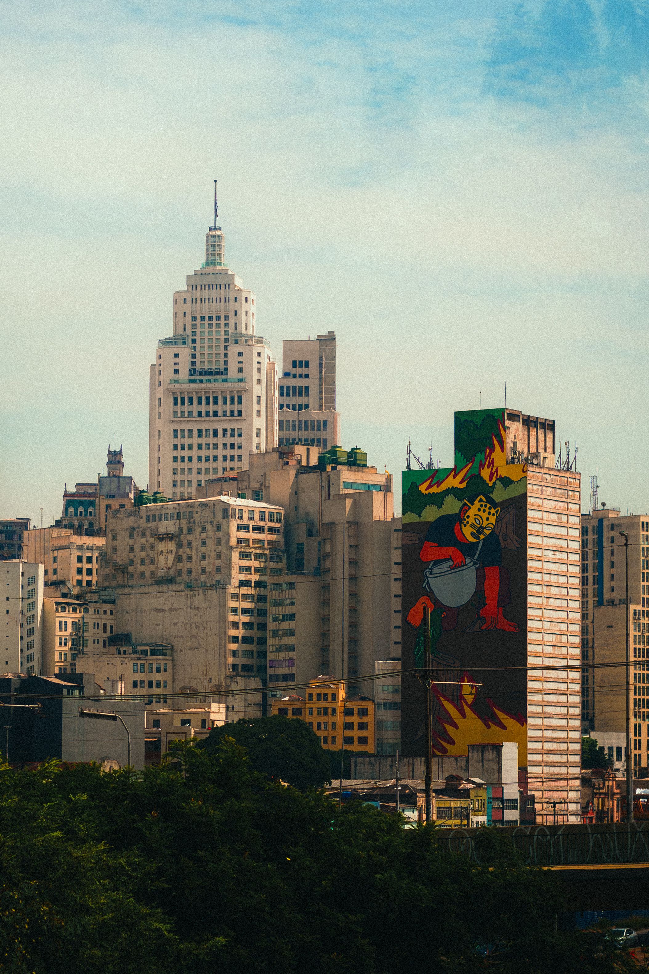 Captivating view of Sao Paulo's skyline featuring a colorful street art mural on a building wall.