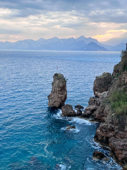 Free Dramatic rocky coastline with ocean view at sunset, perfect for travel inspiration. Stock Photo