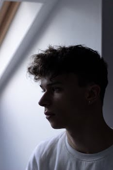 室内柔和光线下，一位时尚年轻人的侧脸肖像