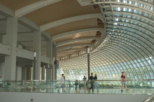 Modern architecture with curved glass walls at Marina Bay Sands, Singapore, capturing daily life indoors.