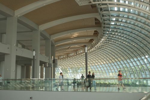 Free Modern architecture with curved glass walls at Marina Bay Sands, Singapore, capturing daily life indoors. Stock Photo