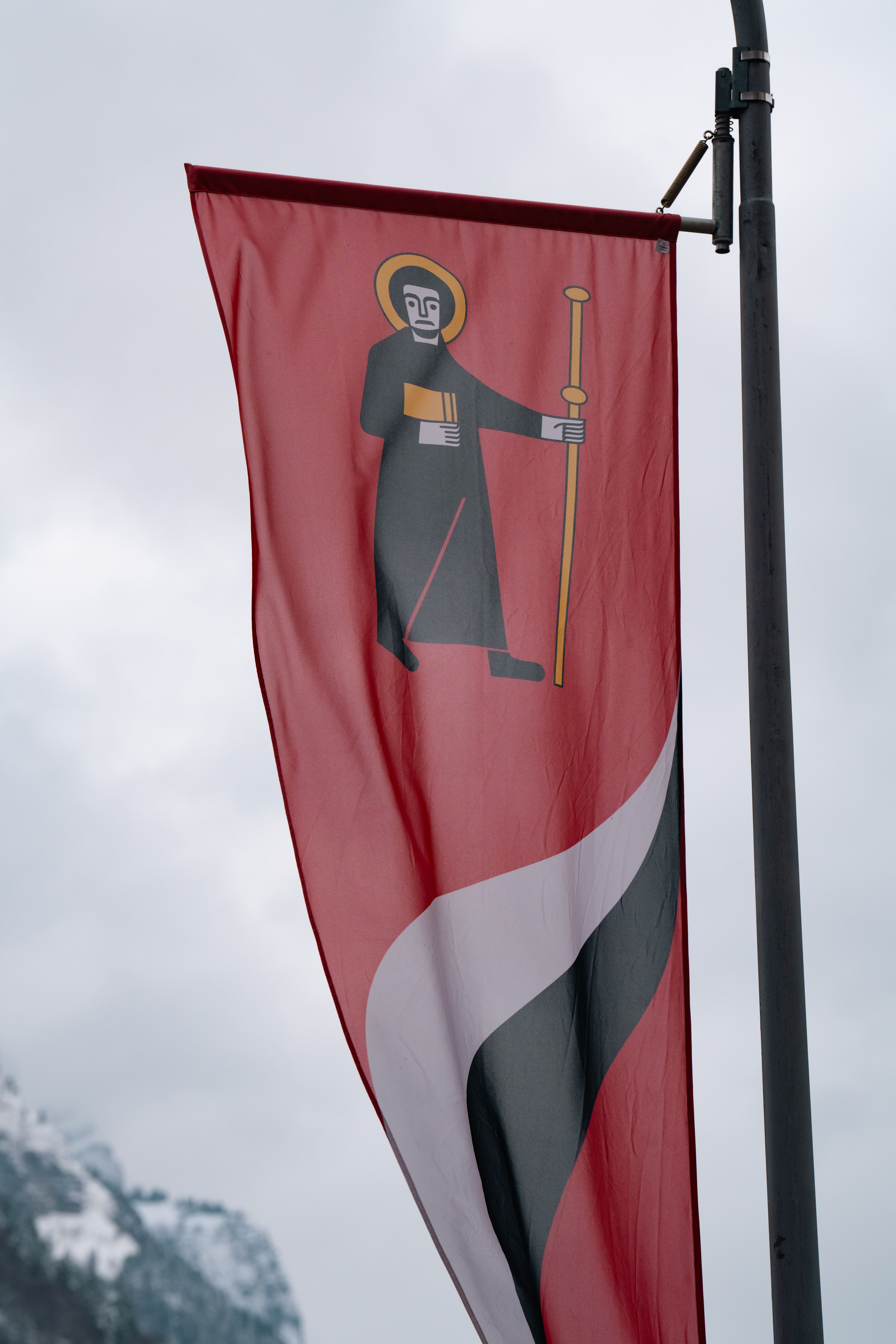 Red Flag with Religious Symbol in Alpine Setting · Free Stock Photo