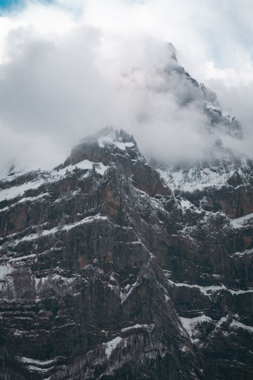 Free Dramatic view of a snow-covered mountain peak enveloped by clouds, capturing nature's majesty. Stock Photo
