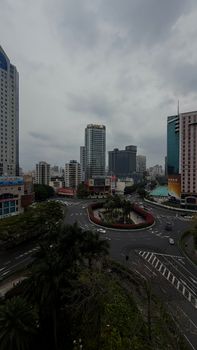 Urban cityscape of Foshan, Guangdong, China, showcasing skyscrapers and a busy roundabout on a cloudy day.