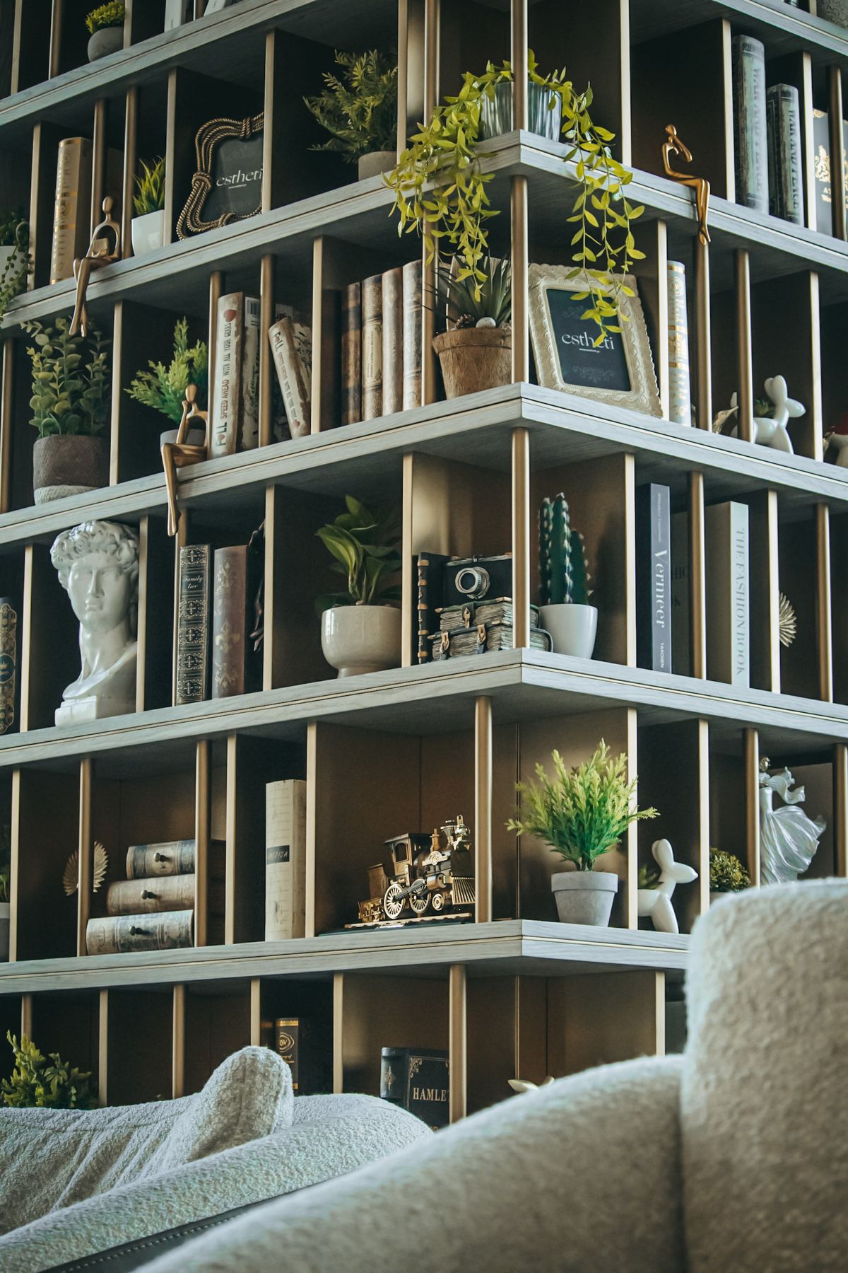 Elegant living room bookshelf styled with plants books and decorative objects