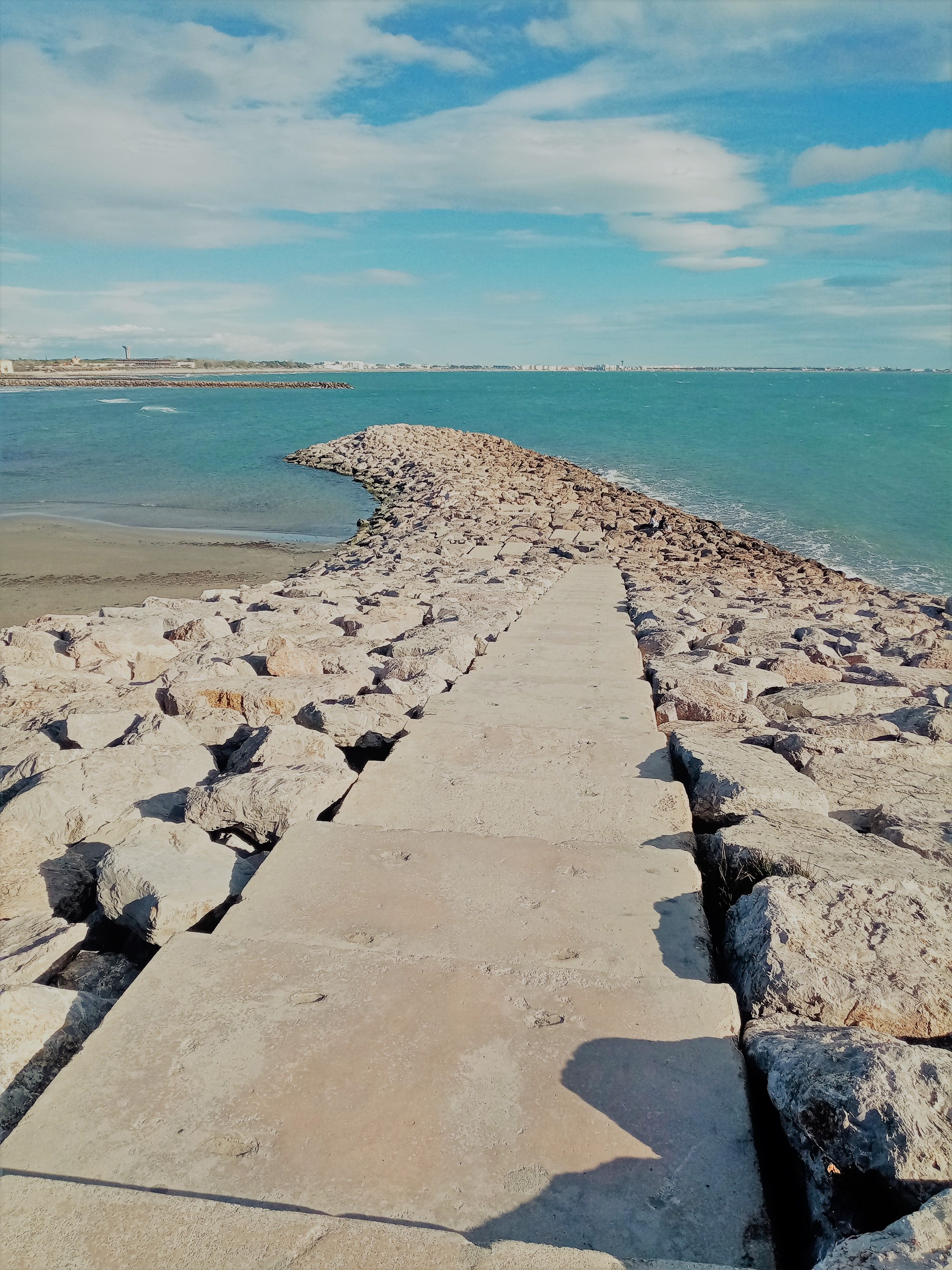 Stone Jetty Extending into the Blue Sea · Free Stock Photo