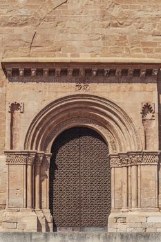 Romanesque church portal showcasing intricate stonework in Lleida, Catalonia, Spain.