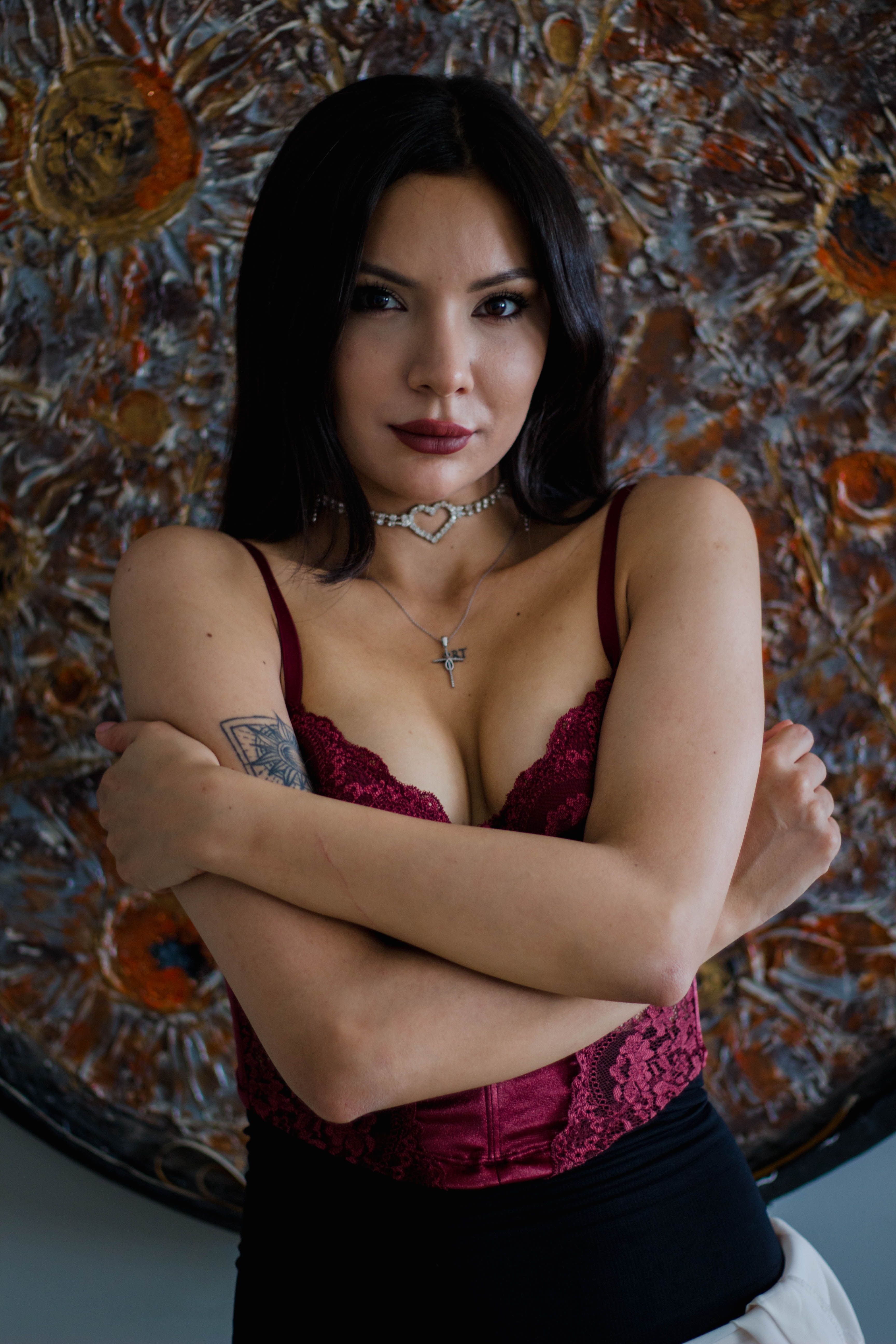 A stylish woman poses confidently against an abstract artwork, exuding elegance.