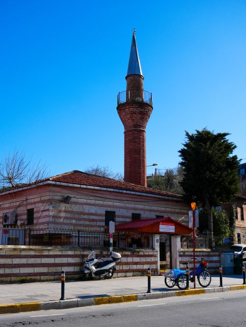 Free A historic mosque with a towering minaret overlooks a street on a bright, clear day. Stock Photo