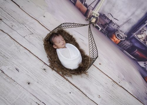 Free Adorable newborn baby peacefully sleeping in a rustic hammock setting, creating a serene and gentle atmosphere. Stock Photo