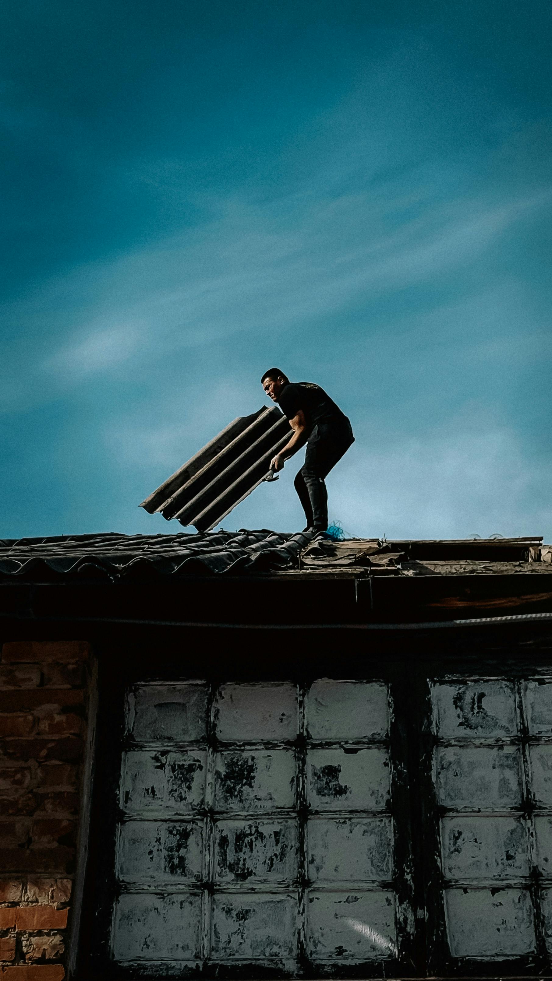 Man inspecting rooftop under blue sky