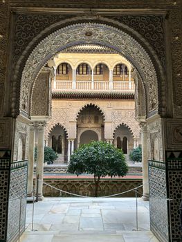 Intricate archway in the Royal Alcázar of Seville with its detailed Moorish design.