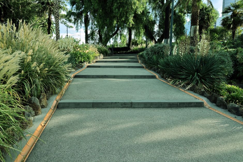 Peaceful garden pathway surrounded by vibrant plants and trees, perfect for relaxation.