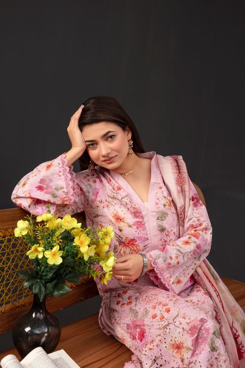 Free Portrait of an elegant woman in a floral dress sitting with yellow flowers, exuding grace and poise. Stock Photo