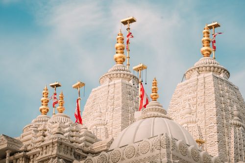 Free Detailed view of the ornate spires of BAPS Shri Swaminarayan Mandir in Bartlett under a clear sky. Stock Photo