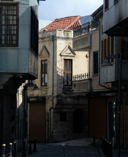 Free Sunlit facade of European alleyway with rustic buildings and cobblestone path. Stock Photo