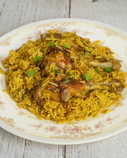 Free Flavorful chicken biryani served on a vintage floral plate. Stock Photo