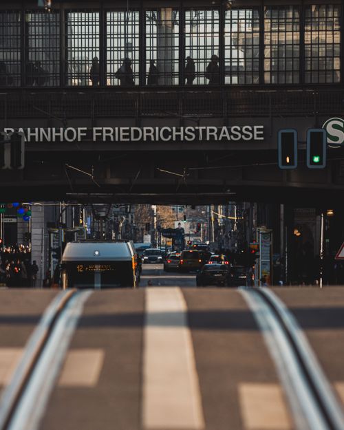 Free Busy urban scene at Bahnhof Friedrichstrasse in Berlin with public transport and commuters. Stock Photo