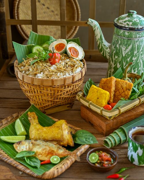 Free Traditional Indonesian meal served with side dishes in woven containers and a vintage teapot. Stock Photo