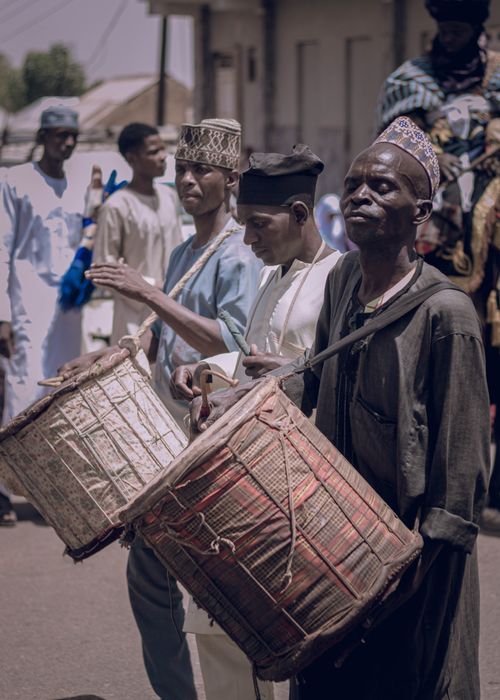 Free A group of street musicians playing traditional drums during a cultural festival. Stock Photo
