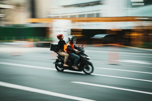 Free Panning shot capturing a fast-moving motorcycle on Makati City street, Philippines. Stock Photo