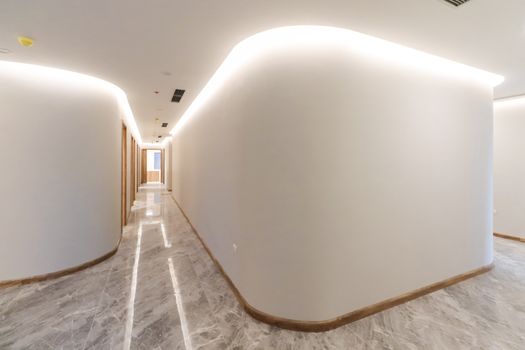 Bright modern hallway with curved walls and soft lighting, showcasing minimalist interior design.