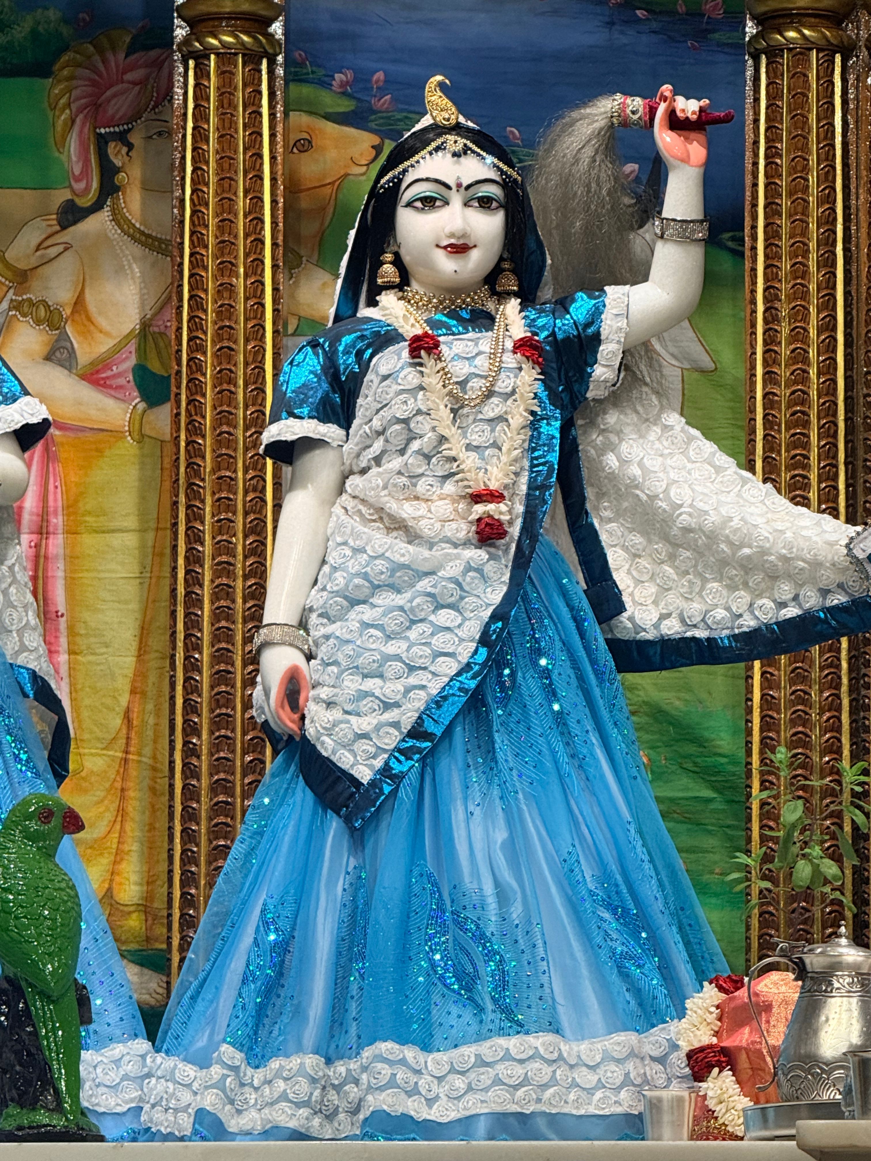 Vivid statue of a deity adorned in blue attire at a temple in Tirupati, India.