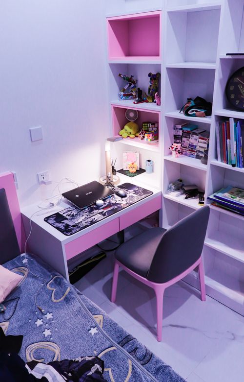 Free A well-organized child's room featuring a pink study desk, shelves, and a cozy bed. Ideal for study inspiration. Stock Photo