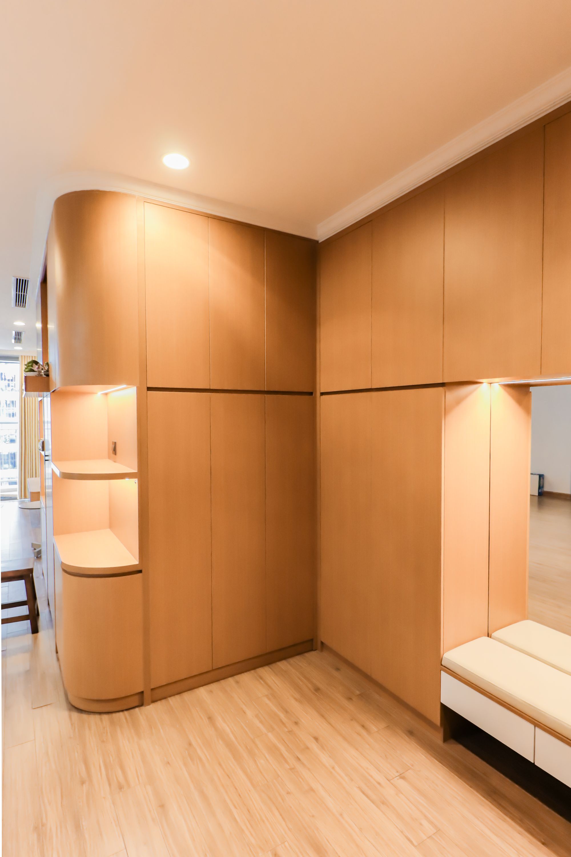 Interior contemporâneo com mobiliário integrado em madeira e iluminação suave.