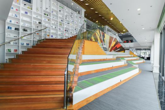 Spacious contemporary interior with colorful staircase and extensive shelving, ideal for design inspiration.
