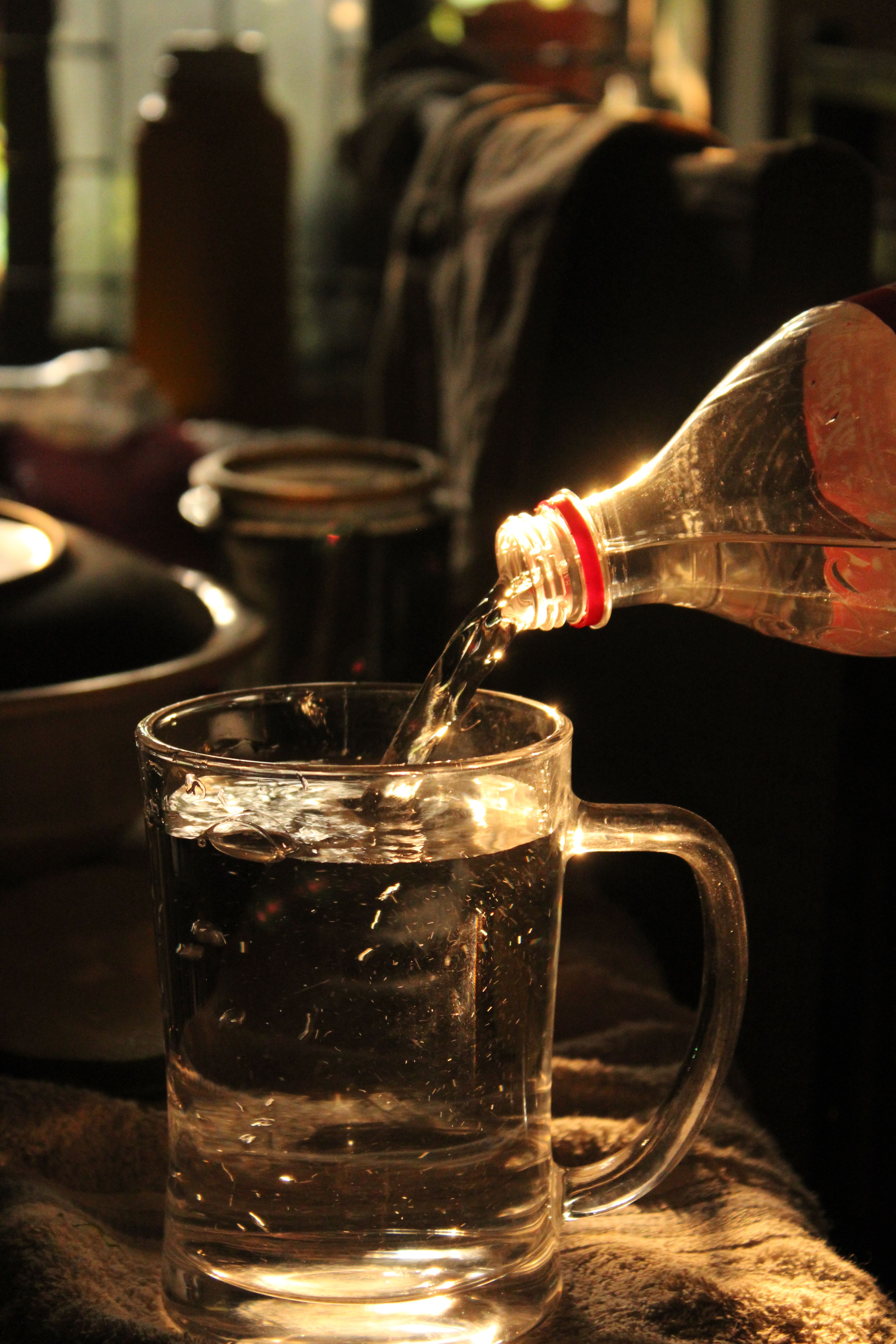 Glass of fennel and jeera water on a wooden table for daily digestion.