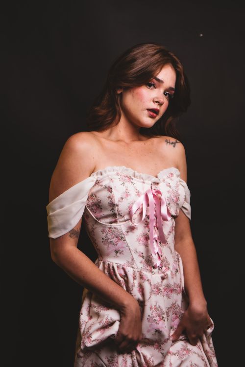 Free Elegant woman in floral dress posing against a dark background, exuding a romantic and vintage feel. Stock Photo