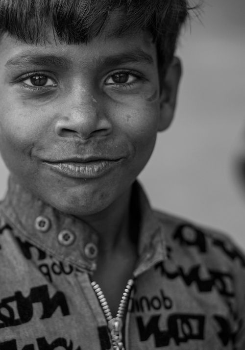 Free Charming black and white portrait of a smiling young child wearing a patterned shirt. Stock Photo