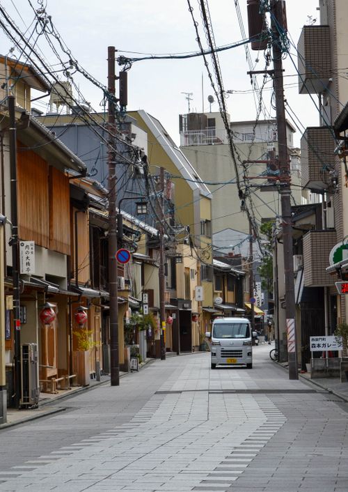 Free A peaceful street scene in Kyoto, Japan, featuring traditional wooden houses and power lines. Stock Photo