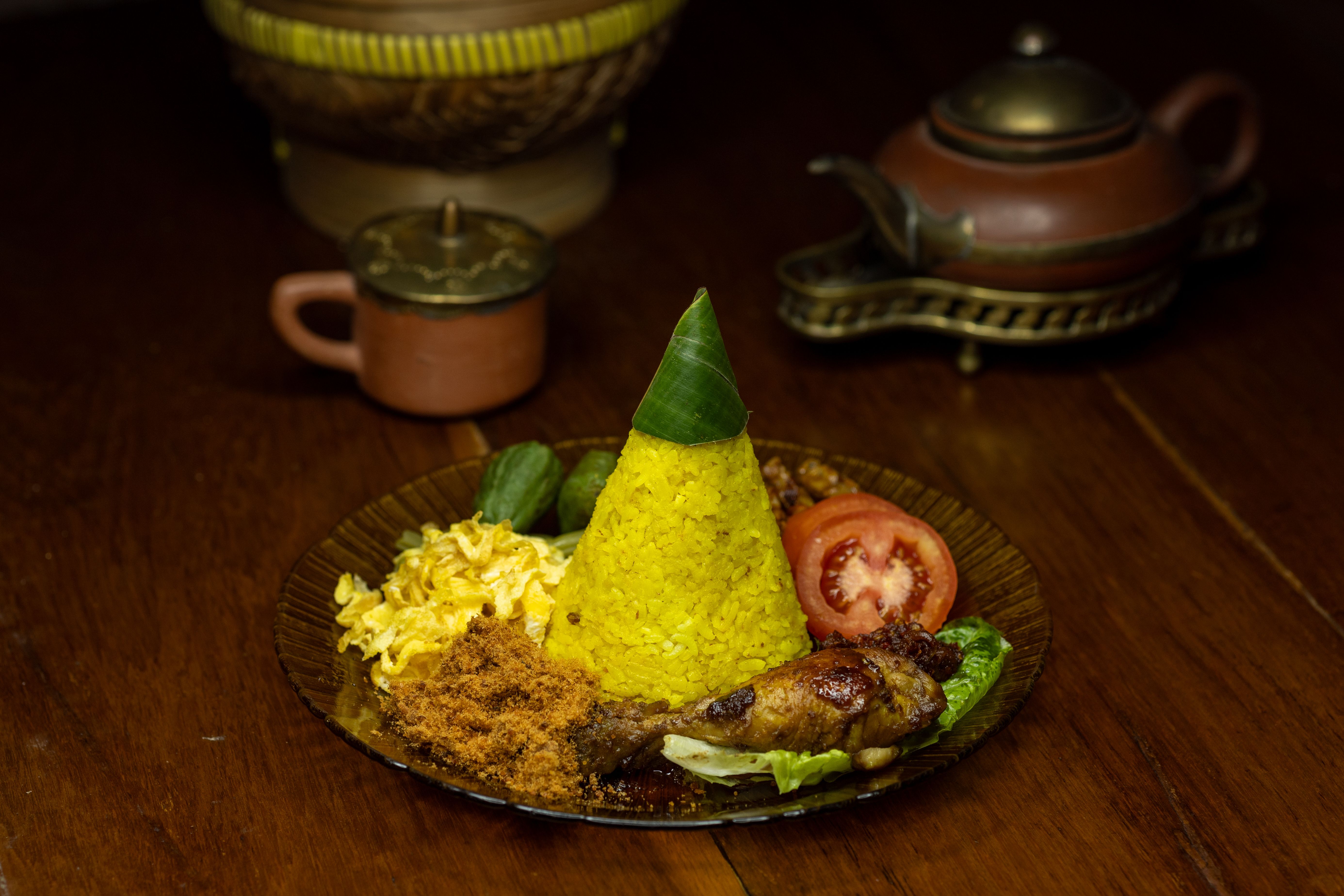 Nasi Tumpeng with sides, a festive Indonesian dish, traditionally served at celebrations.