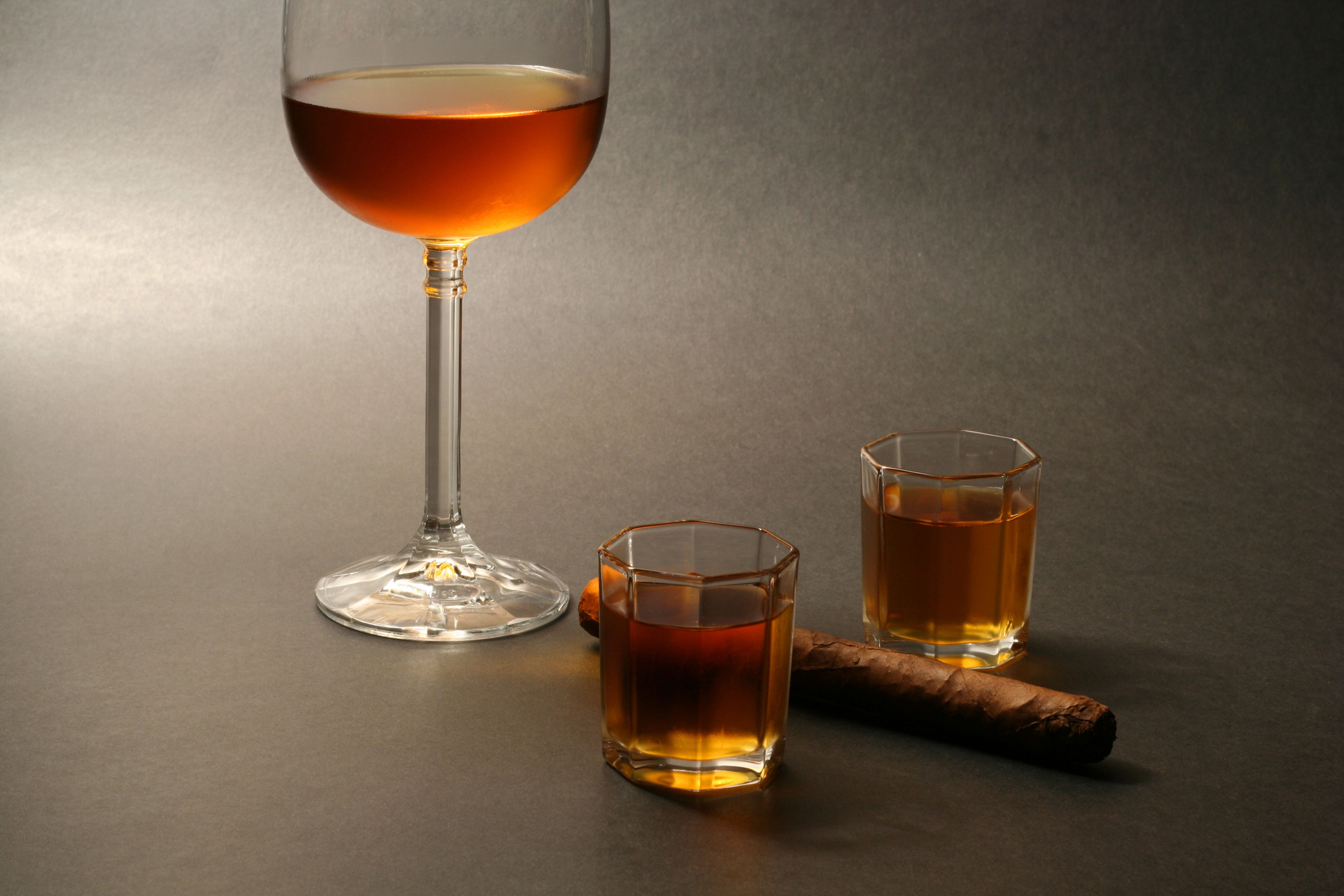 Luxurious composition of cognac glasses and a cigar on a dark background.