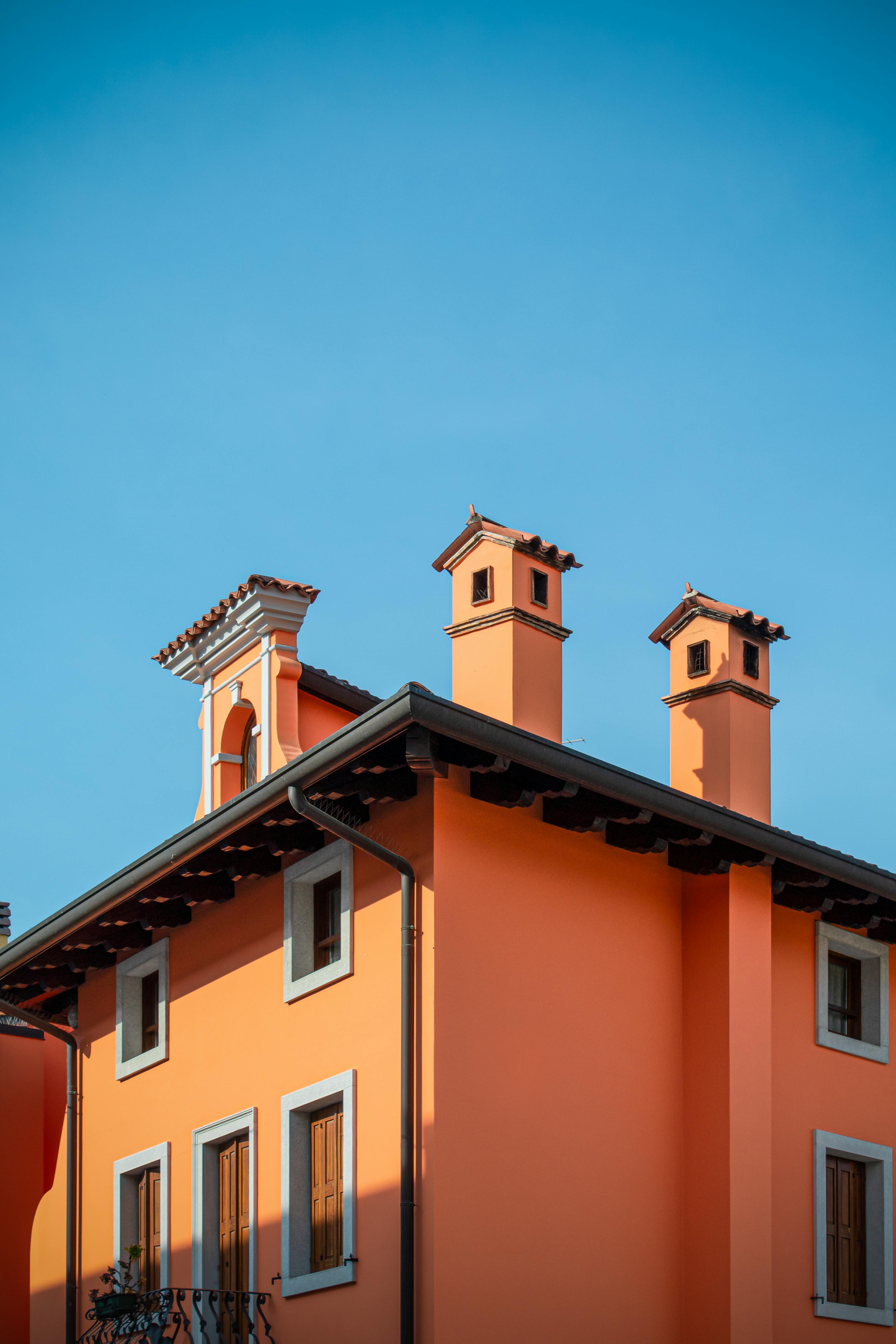 Vibrant orange building with chimneys in Palmanova, showcasing Italian architectural style.