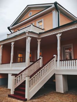 A beautiful classic house featuring decorative columns and a wooden staircase.
