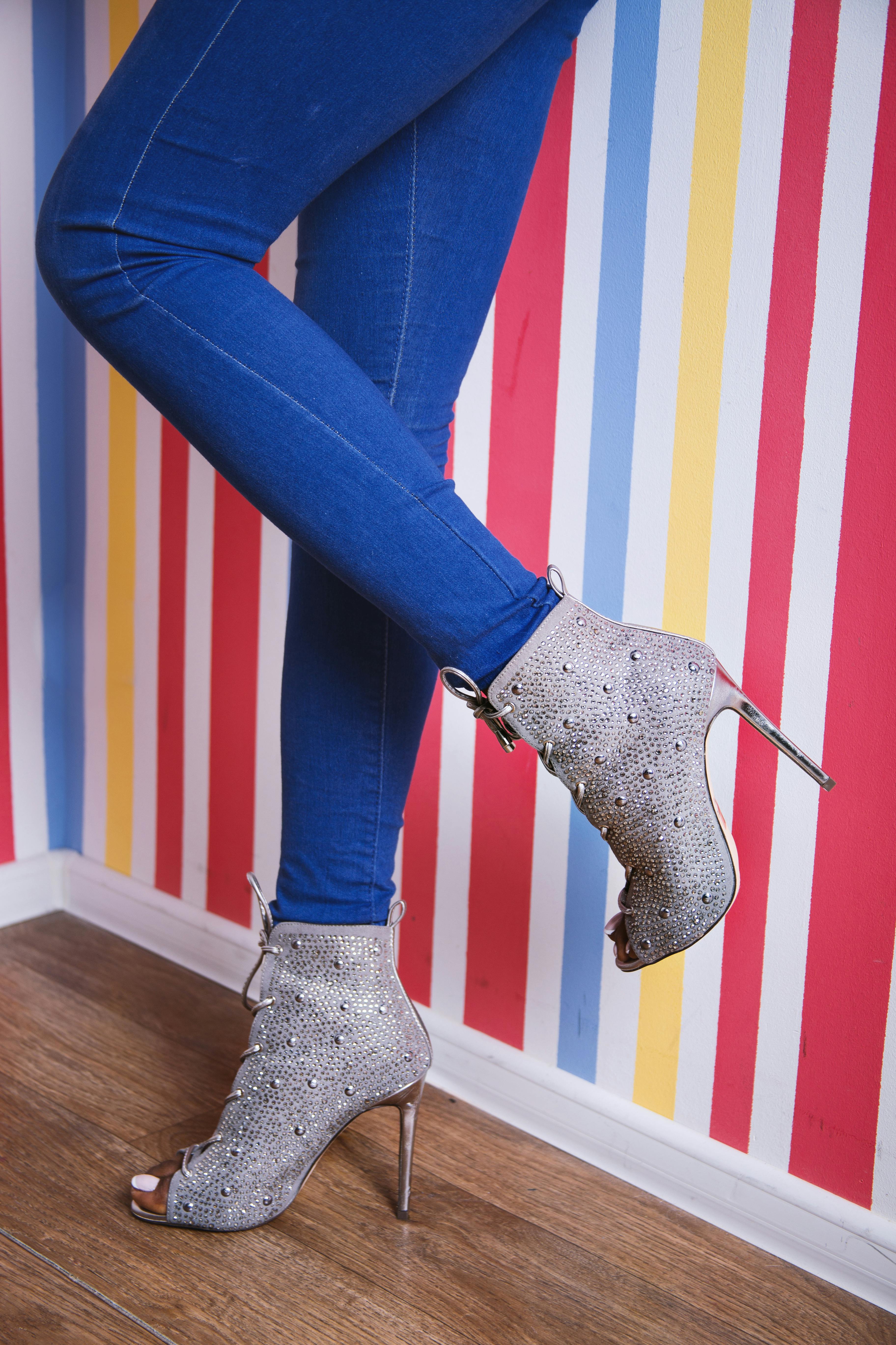 woman in blue denim jeans and gray heeled shoes