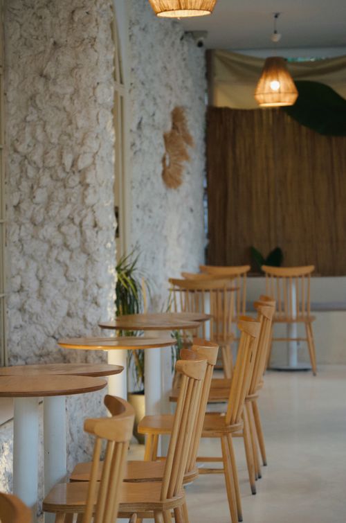 Free A charming Turkish cafe interior featuring wooden chairs and tables against a rustic stone wall. Stock Photo