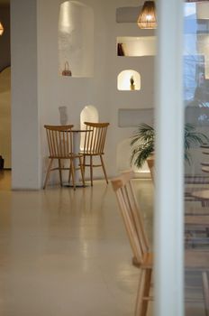 Welcoming minimalist cafe interior with wooden chairs and warm lighting in Türkiye.